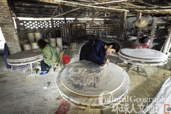 陶瓷园内，工人正在细心地描绘瓷胚