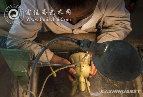 在乌鲁木齐一家玉器雕刻厂车间，姜柏东在对一件玉器斝进行雕琢（4月24日摄）。