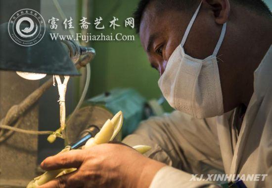 在乌鲁木齐一家玉器雕刻厂车间，姜柏东在对一件玉器斝进行雕琢（4月24日摄）。